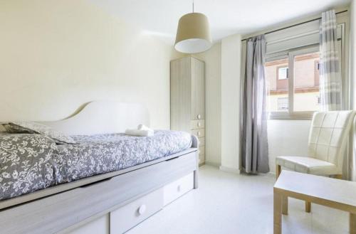 ein Schlafzimmer mit einem Bett und einem Stuhl und einem Fenster in der Unterkunft Azucarera 2 Room- HOME RENT MALAGA in Torre del Mar
