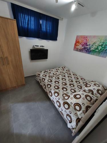 un letto in una stanza con un dipinto sul muro di apartman19 a Podgorica