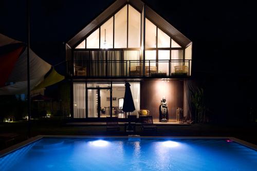 a house with a swimming pool at night at Meadows Villa in Uluwatu