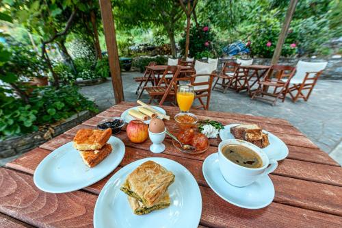 a wooden table with plates of food and a cup of coffee at Heliodora in Kissós