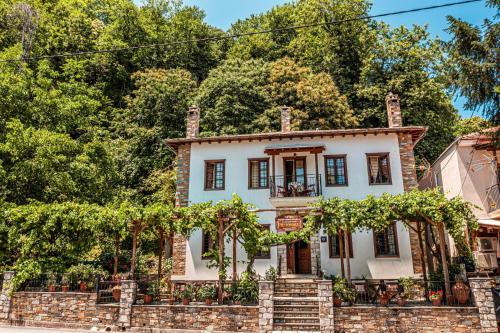 an old brick house with trees in the background at Heliodora in Kissós