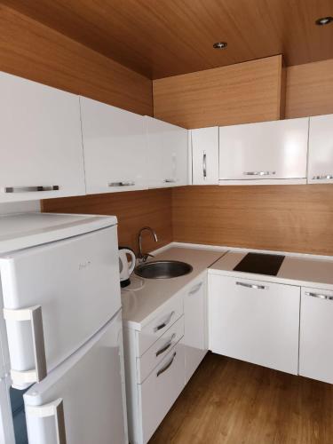 a white kitchen with white cabinets and a sink at Sweet Homes in Sunny Beach