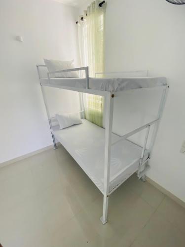 a white bunk bed in a white room at Truly Hostel Kandy in Kandy