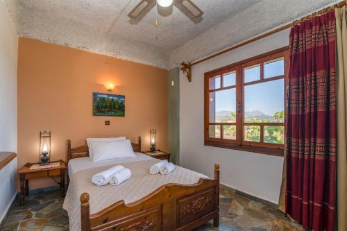 a bedroom with a bed with towels on it at Drapanias BeachFront Apartments - Marinakis in Kissamos