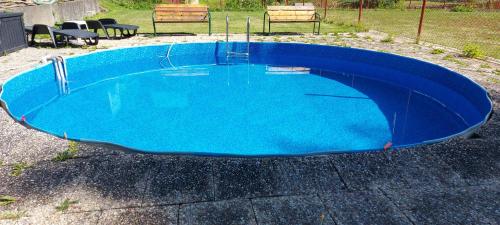 a small blue pool with chairs around it at Penzion Svojanov in Svojanov