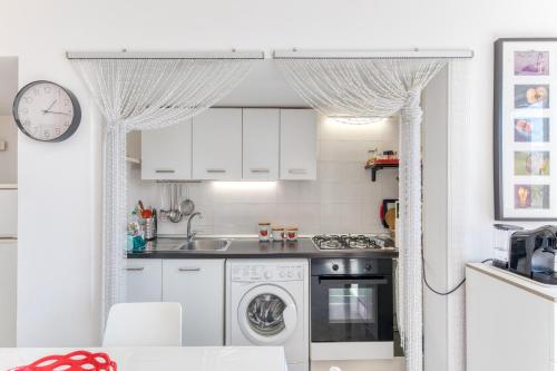 a kitchen with white cabinets and a dishwasher at Villa Emilia in Andrano