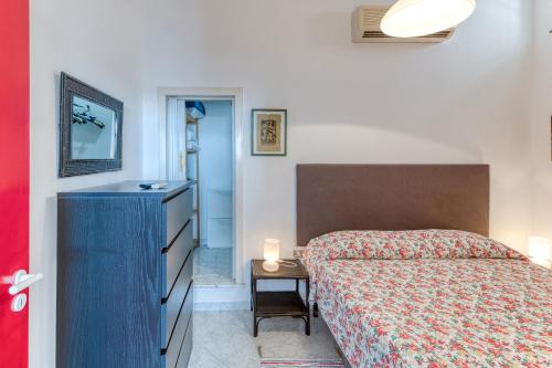 a bedroom with a bed and a blue dresser and a table at Villa Emilia in Andrano