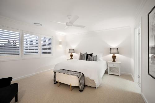 a white bedroom with a white bed and a window at Urban Haven Central Wagga in Wagga Wagga