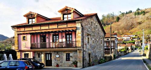 an old building with a balcony on a street at Posada Rural Ochohermanas in Las Fraguas