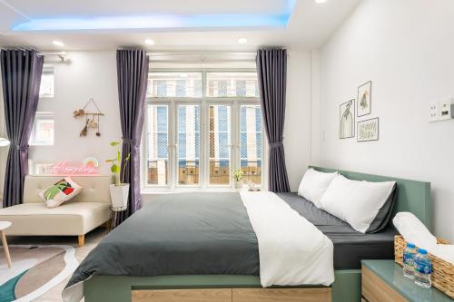 a bedroom with a bed and a large window at Happy house studio in Ho Chi Minh City