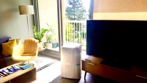 un salon avec une télévision à écran plat et une chaise dans l'établissement One Bedroom Apartment Centre Lyon, à Lyon