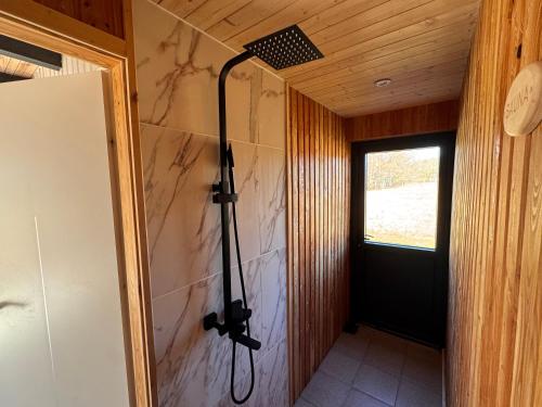 a shower in a room with a wall at Sunset Village in Aglona