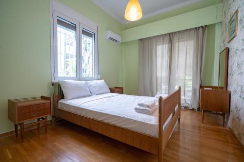 a bedroom with a bed with white sheets and a window at Retro 2-Bdrm House Near Metro in Heraklion by ΜΡS in Athens
