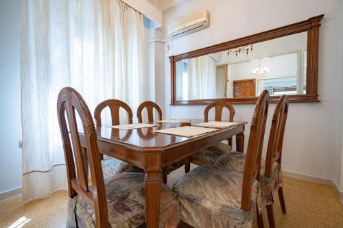 a dining room table with chairs and a mirror at Retro 2-Bdrm House Near Metro in Heraklion by ΜΡS in Athens