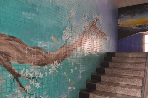 a mural of a bird on a wall next to stairs at Notting Hill Hostel in Bao'an