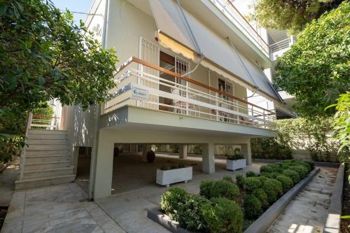 a building with a balcony and some bushes at Retro 2-Bdrm House Near Metro in Heraklion by ΜΡS in Athens