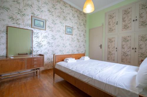 a bedroom with a bed and a dresser and a mirror at Retro 2-Bdrm House Near Metro in Heraklion by ΜΡS in Athens