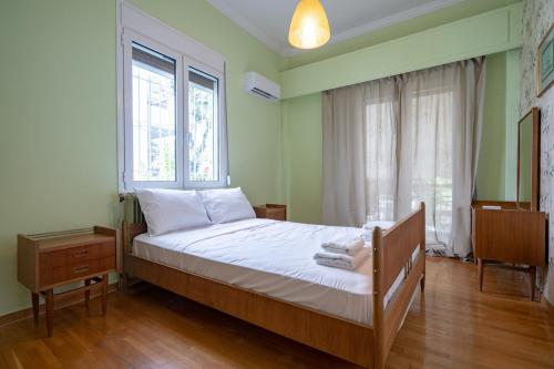 a bedroom with a bed with white sheets and a window at Retro 2-Bdrm House Near Metro in Heraklion by ΜΡS in Athens