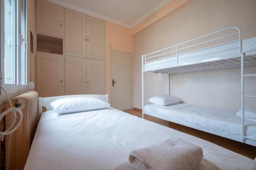 a bedroom with two bunk beds and a window at Retro 2-Bdrm House Near Metro in Heraklion by ΜΡS in Athens