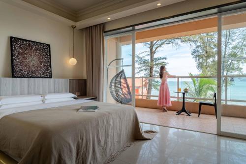 a woman in a pink dress is standing on a balcony at Shenzhen Maancoco Seaview Villa Jiaochangwei Coastline in Dapeng