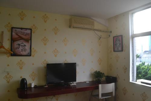 a living room with a television on a wall at Notting Hill Hostel in Bao'an