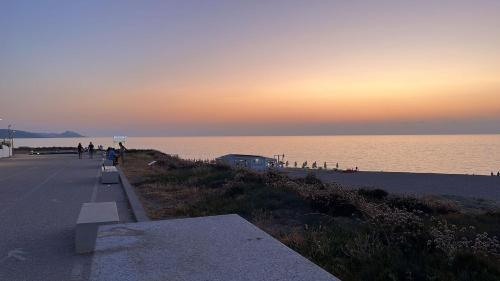 a group of people walking along the beach at sunset at Affittimoderni Valledoria - Costa Dora in Valledoria