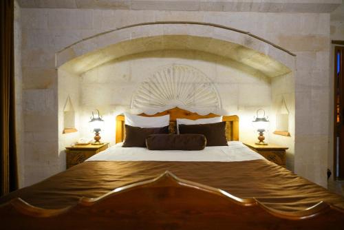 a bedroom with a large bed with a large headboard at Harman Cave Hotel in Goreme