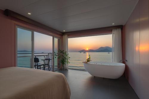 a bedroom with a tub and a view of the ocean at Shenzhen Maancoco Seaview Villa Jiaochangwei Coastline in Dapeng
