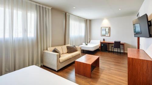 a living room with a couch and a table in a room at Sercotel Ciutat de Montcada in Montcada i Reixac