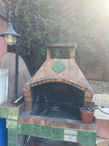 ラ・テュルビーにあるBelle villa avec piscine proche monacoの上部にライトが付いた屋外のレンガ造りのオーブン