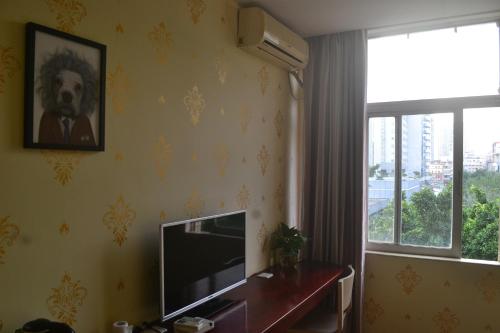 a living room with a television and a window at Notting Hill Hostel in Bao'an