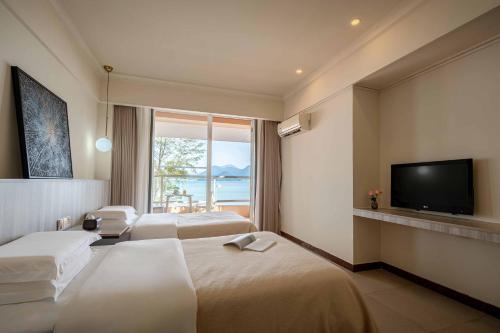 a hotel room with two beds and a flat screen tv at Shenzhen Maancoco Seaview Villa Jiaochangwei Coastline in Dapeng