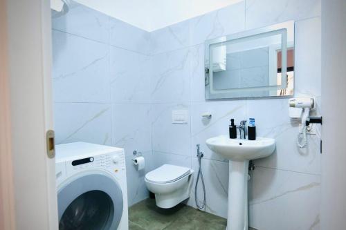 a white bathroom with a washing machine and a sink at Aren 1 in Vlorë