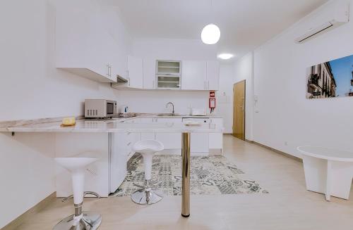 a white kitchen with a counter and a sink at Apartamentos Sol & Ria in Olhão