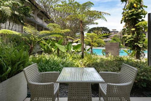 a table and chairs on a patio with a pool at Sheraton Bandung Hotel & Towers in Bandung