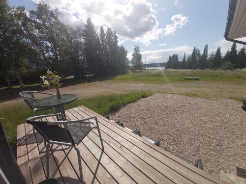a table and chairs on a deck with a view of a field at Guesthouse Northern Star in Muonio