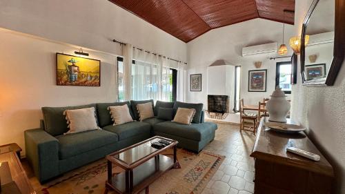 a living room with a green couch and a table at Gemini by Check-in Portugal in Albufeira