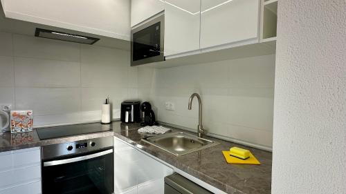 a kitchen with a sink and a counter top at Gemini by Check-in Portugal in Albufeira