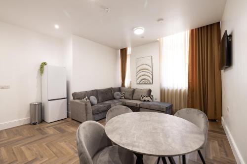 a living room with a table and a couch at Luxury City Retreat Perfect for Business & Families & Free Gym By The Pocklington - The New Walk Suite in Leicester