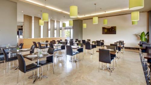 a restaurant with tables and chairs in a room at Sercotel Ciutat de Montcada in Montcada i Reixac