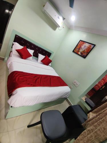 a bedroom with a bed with red pillows and a chair at Hotelchocolateinn in Visakhapatnam