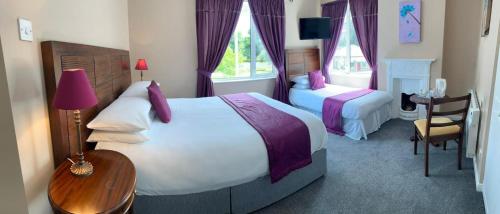 a hotel room with two beds and a table at Grand Central Hotel in Ó Méith