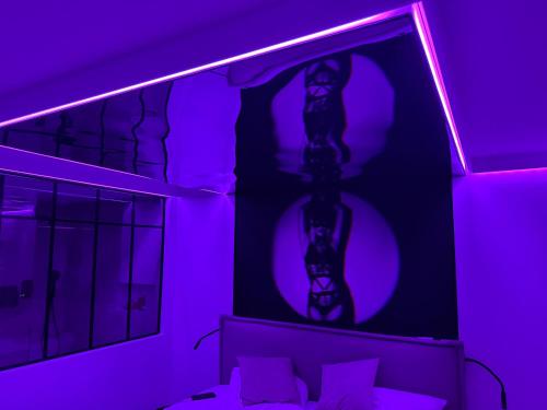 a purple room with a bed and a mirror at Duchesse Luxe Cap - Naturiste in Cap d'Agde