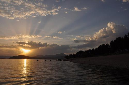 a sunset over a body of water with the sun shining at Apartman Marienka in Liptovský Trnovec