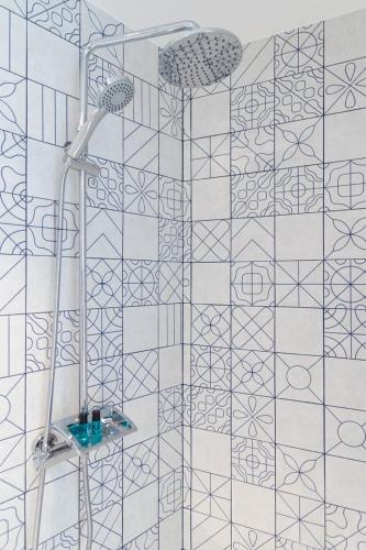 a shower in a bathroom with a tile wall at A'Mar by Alojamento Ideal in Póvoa de Varzim