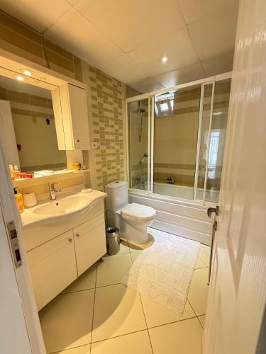 a bathroom with a toilet and a sink and a shower at Seaview 2BR 2BA Apartment in Antalya Lara Cliffs in Antalya