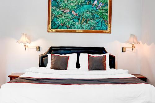 Un dormitorio con una cama con un cuadro en la pared. en Dancenter The Ethnic Hotel, en Bandung