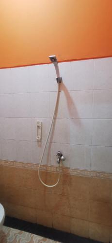 a shower in a bathroom with a hose on a wall at Hotel O Classic Guesthouse in Balikpapan