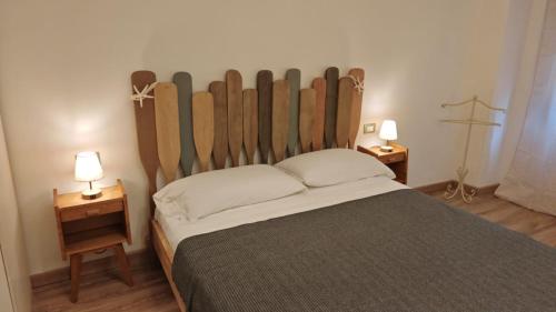 a bedroom with a bed with a large wooden headboard at La casa di Giacomo in Portovenere