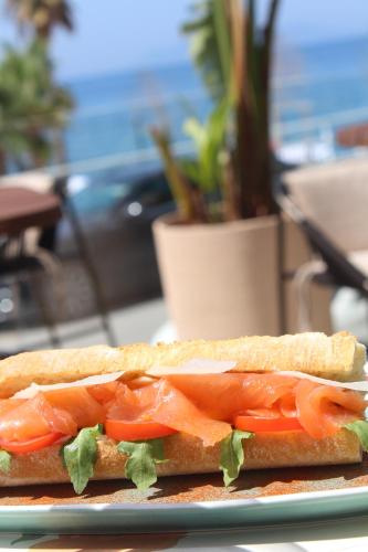 a sandwich with tomatoes and lettuce on a plate at Azar Luxury Suites in Vlorë